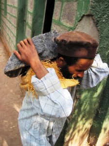 A monk carries another rock up the hill to the church...